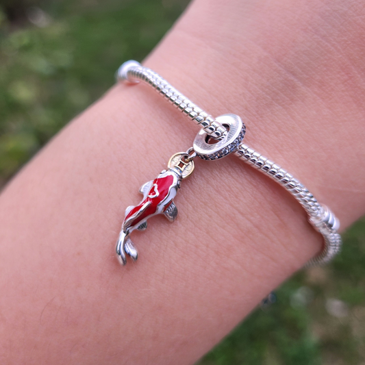 Célébrez la prospérité et la chance avec ce charm pendentif Carpe Poisson, inspiré par les traditions du Nouvel An chinois. Réalisé en argent sterling 925, ce charm détaillé symbolise la persévérance et le succès, des valeurs profondément ancrées dans la culture chinoise. Compatible avec les bracelets Pandora, ce pendentif élégant est parfait pour marquer un nouveau départ et attirer la bonne fortune tout au long de l'année.