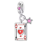 Ce charm ludique audacieux expose une carte rectangulaire blanche aux bordures noires ondulées, ornée d'un grand cœur central rouge émaillé et deux cœurs latéraux assortis, surmontée d'un petit symbole pique rouge vif. Une étoile rose cristalline suspendue et un cœur violet sur l'anneau ajoutent éclat scintillant au pendentif. Symbole de chance amoureuse et esprit joueur, il anime les bracelets d'une vibe espiègle irrésistible.

Caractéristiques

Matière : Argent 925 avec émail rouge, noir, blanc et cristau