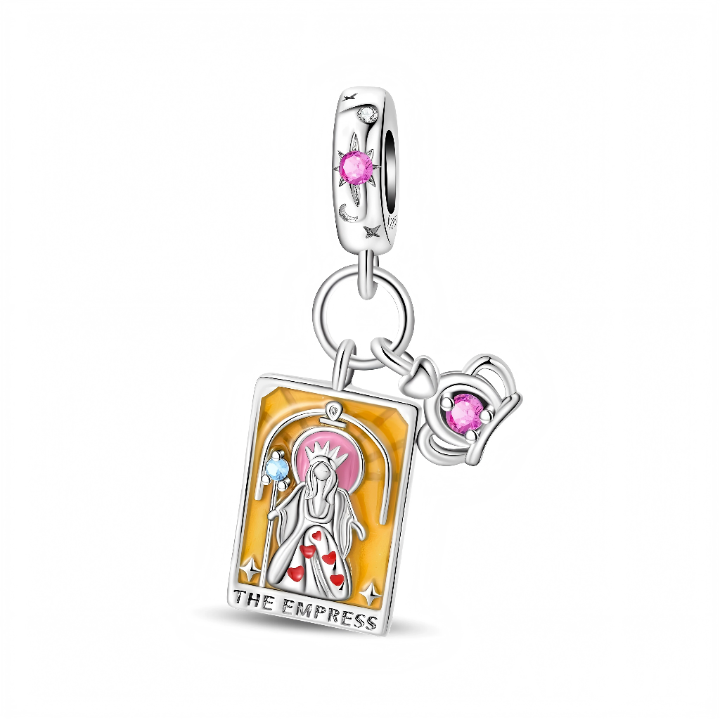 La bélière en argent 925 est ornée d’étoiles gravées et d’un cristal rond rose au centre, qui rappelle la douceur et l’énergie féminine de l’Impératrice. Le pendentif principal représente une carte de tarot émaillée jaune et rose avec une figure d’Impératrice blanche décorée de petits cœurs rouges, tandis qu’un second pendentif montre une couronne miniature pavée d’un cristal rose assorti.