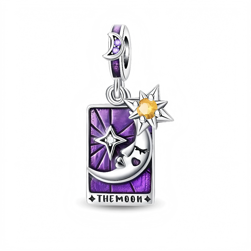 Ce charm pendentif en argent s’inspire des cartes de tarot avec un rectangle violet profond façon vitrail, décoré d’un croissant de lune au visage féminin, d’une étoile scintillante et d’un grand soleil serti d’un cristal jaune. La bélière, ornée d’un petit croissant de lune et de pierres violettes, renforce l’aura mystique de ce bijou où l’inscription “THE MOON” figure au bas de la carte.