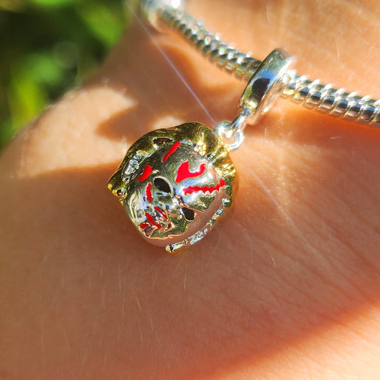 Apportez une touche de terreur à votre collection avec ce charm inspiré de Chucky, le terrifiant personnage de la saga Jeu d'Enfant. Conçu en argent sterling S925, ce charm capture les détails effrayants de la poupée meurtrière, avec son sourire sinistre et son regard perçant, rendant hommage à l'un des personnages les plus emblématiques du cinéma d'horreur.