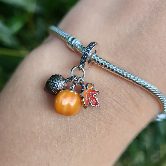 Célébrez la saison d'automne avec ce Charm - Citrouille, Gland et Feuille d'Automne, en argent sterling S925. Ce charm magnifique réunit trois symboles emblématiques de l'automne : une citrouille, un gland et une feuille délicate, représentant la récolte et les couleurs chaleureuses de cette période magique. Parfait pour ceux qui aiment l'esprit automnal, ce charm ajoute une touche de chaleur et de nature à votre collection.