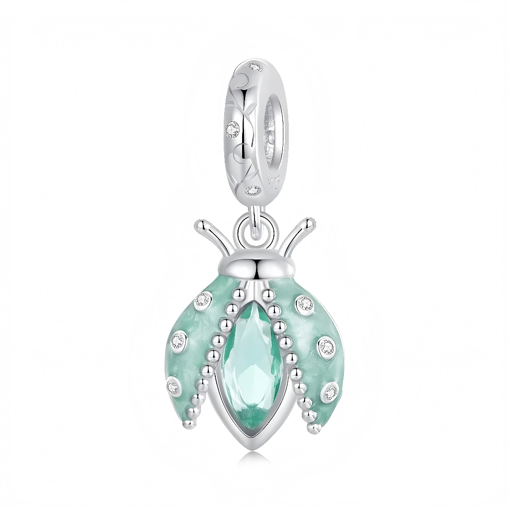 Ce charm pendentif en argent 925 représente une coccinelle stylisée aux ailes émaillées vert menthe, parsemées de petits zirconias clairs pour un effet scintillant. Au centre, un cristal fuselé assorti capte la lumière et donne à la coccinelle un look frais et délicat, parfait pour évoquer le printemps.