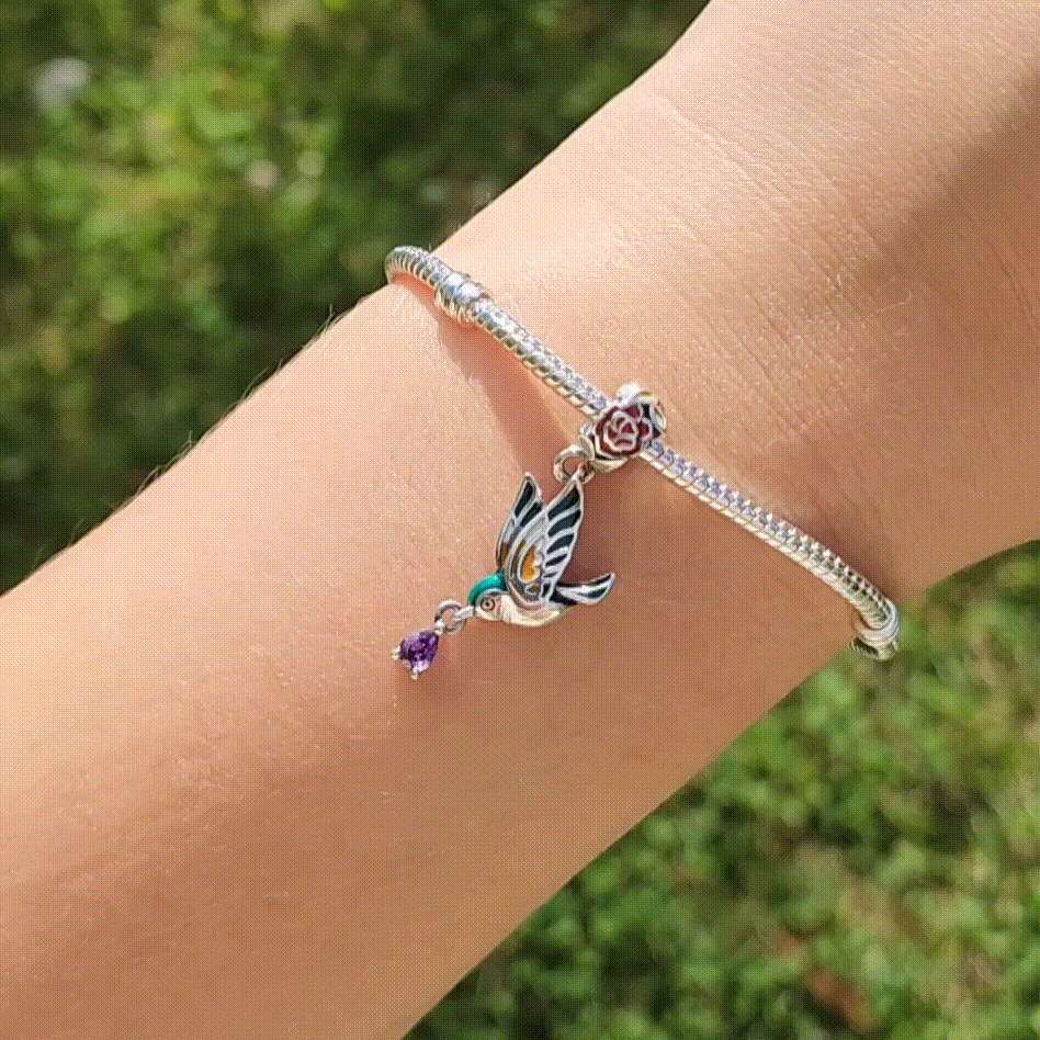 Ajoutez une touche de grâce et de beauté naturelle à votre collection avec ce charm représentant un colibri en vol, orné de délicates pivoines. Fabriqué en argent sterling S925, ce charm allie élégance et finesse, capturant la légèreté et le charme du colibri ainsi que la beauté des pivoines.