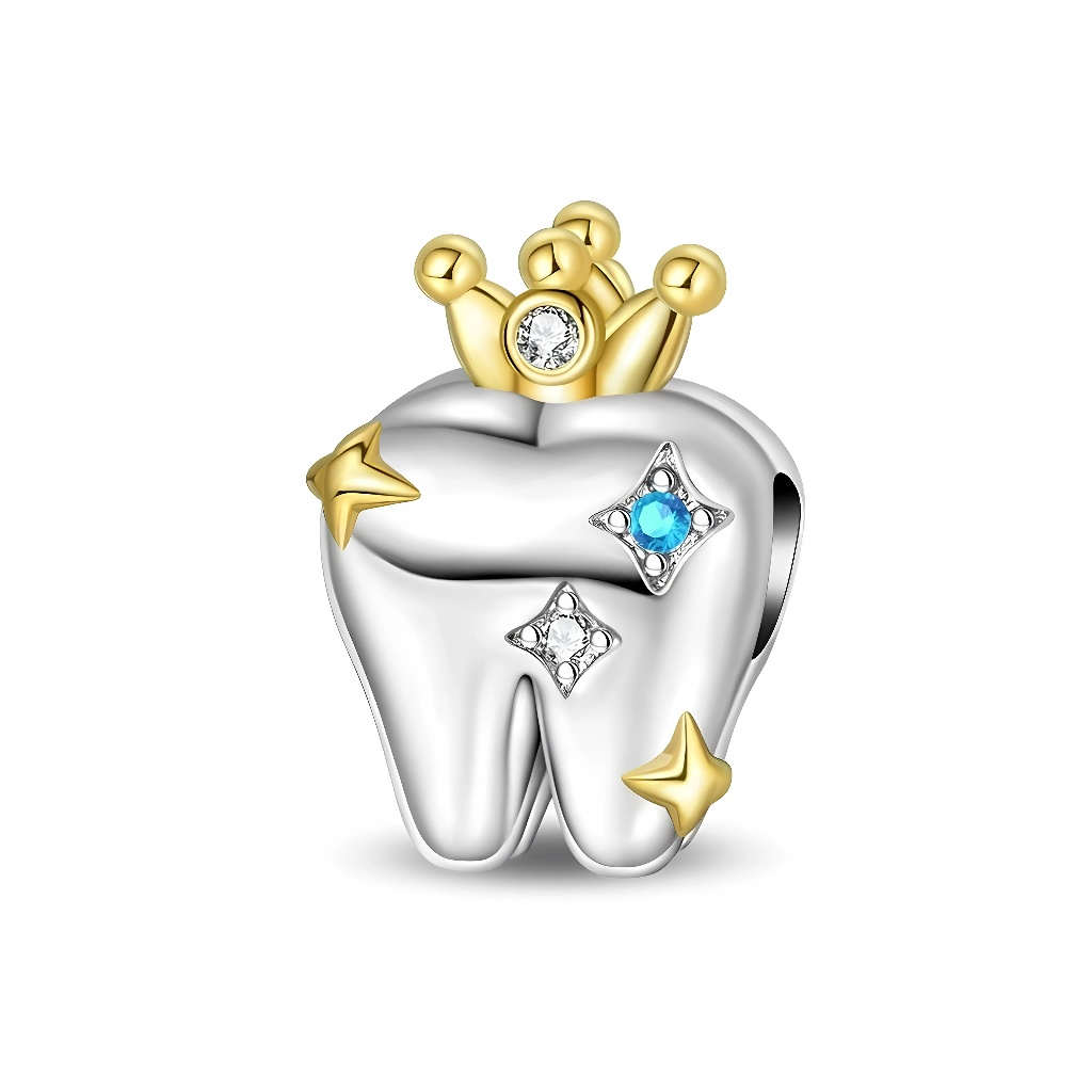 Ce charm pendentif représente une dent stylisée en argent, coiffée d’une petite couronne dorée sertie d’un cristal clair, comme un clin d’œil à la “dent de roi” ou à un sourire précieux. La surface de la dent est décorée d’étoiles dorées et de motifs scintillants sertis de cristaux blancs et bleu vif, rappelant l’éclat d’un sourire parfaitement soigné.