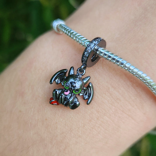 Ajoutez une touche de mystère et de puissance à votre collection avec ce charm en forme de dragon noir. Fabriqué en argent sterling 925, ce charm de haute qualité est compatible avec tous les bracelets Pandora, vous permettant d'incorporer un symbole de force et de légende à votre bijou préféré. Parfait pour les amateurs de mythologie et de créatures fantastiques, ce charm capture l'élégance féroce d'un dragon noir avec des détails finement sculptés, ajoutant une note audacieuse et majestueuse à votre brace