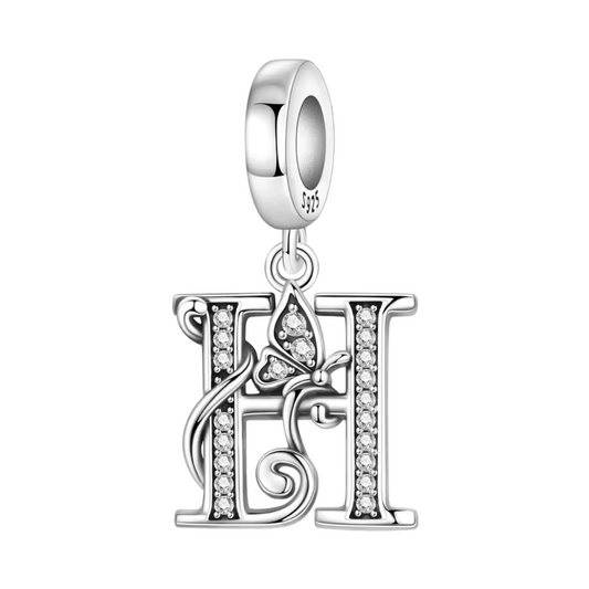 Exprimez votre élégance et votre personnalité avec ce charm pendentif en argent 925 représentant la lettre "H" stylisée dans un design raffiné. La lettre est ornée de strass scintillants qui ajoutent une touche de brillance délicate, accompagnée d’un petit papillon argenté symbolisant légèreté et liberté. Un bijou chic et sophistiqué, parfait pour personnaliser votre bracelet ou offrir un cadeau significatif.