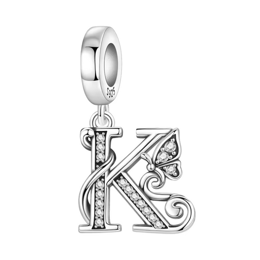 Exprimez votre élégance et votre personnalité avec ce charm pendentif en argent 925 représentant la lettre "K" stylisée dans un design raffiné. La lettre est ornée de strass scintillants qui ajoutent une touche de brillance délicate, accompagnée d’un petit papillon argenté symbolisant légèreté et liberté. Un bijou chic et sophistiqué, parfait pour personnaliser votre bracelet ou offrir un cadeau significatif.
