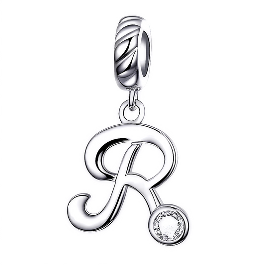 Ajoutez une touche raffinée et personnalisée à votre bracelet avec ce charm pendentif en argent 925 représentant la lettre "R". Son design élégant est orné d’un strass blanc scintillant qui capte la lumière avec délicatesse, offrant un bijou simple, charmant et plein de signification. Parfait à porter chaque jour ou à offrir en cadeau pour un style sophistiqué et unique.