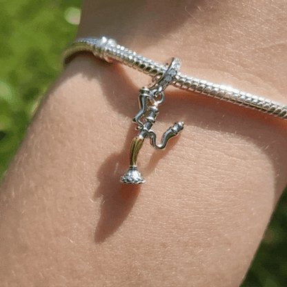 Faites briller votre collection avec l’élégance enjouée de Lumière, le célèbre chandelier de La Belle et la Bête. Ce charm en argent 925 capture toute la personnalité chaleureuse et raffinée du personnage, avec ses bras candélabres et son sourire accueillant. Un bijou étincelant qui évoque la magie, l’hospitalité et l’esprit inoubliable du conte enchanté.