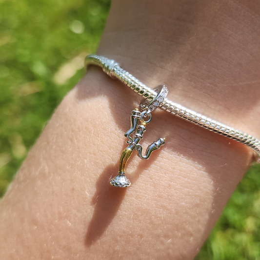 Faites briller votre collection avec l’élégance enjouée de Lumière, le célèbre chandelier de La Belle et la Bête. Ce charm en argent 925 capture toute la personnalité chaleureuse et raffinée du personnage, avec ses bras candélabres et son sourire accueillant. Un bijou étincelant qui évoque la magie, l’hospitalité et l’esprit inoubliable du conte enchanté.