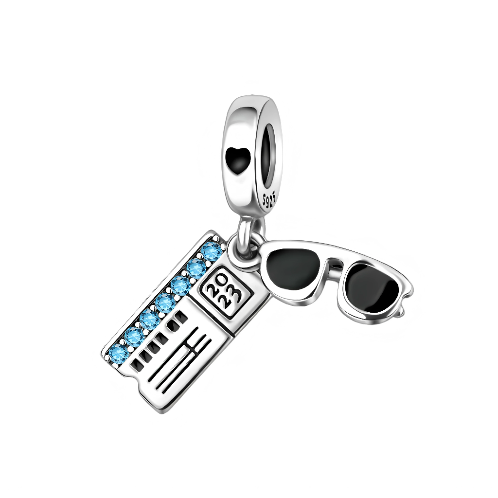 Ce charm pendentif en argent capture l’esprit des vacances avec deux symboles forts du voyage : une paire de lunettes de soleil noires au style tendance et un billet d’avion détaillé marqué “2023”, orné d’une rangée de cristaux bleus étincelants qui rappellent le ciel et la mer. Les deux pendentifs mobiles créent un effet dynamique, parfait pour celles et ceux qui rêvent d’escapades, de city-trips et de séjours au soleil.