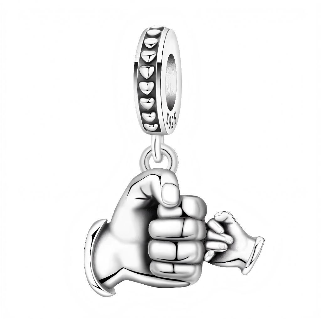 Ce charm pendant en argent 925 représente une grande main d’adulte serrant tendrement le poing d’une petite main d’enfant, symbole puissant de protection, de lien familial et d’amour inconditionnel. L’anneau est décoré de petits cœurs en relief tout autour et porte le poinçon 925, ce qui renforce l’aspect précieux et affectif du bijou.