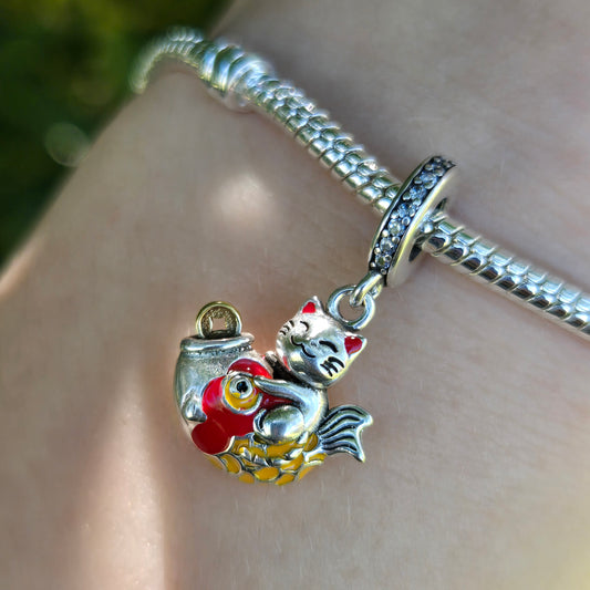 Invitez la chance et la prospérité dans votre vie avec ce charm inspiré du célèbre Maneki Neko, le chat porte-bonheur japonais. Fabriqué en argent sterling S925, ce charm représente le Maneki Neko levant la patte, symbole d'accueil de la fortune et du bonheur. Détail parfait pour célébrer le Nouvel An chinois ou tout autre événement festif. Ce charm élégant est compatible avec les bracelets Pandora et ajoutera une touche unique et porteuse de sens à votre collection.