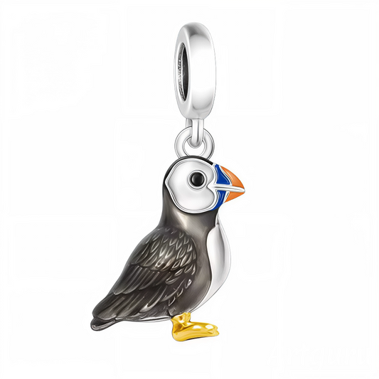 Apportez une touche d’élégance et de contraste à votre collection avec ce charm pendentif en argent 925 représentant un oiseau noir au plumage profond. Ses pattes délicatement dorées et son bec aux teintes bleu et orange apportent une subtile explosion de couleur et de raffinement à ce bijou unique. Parfait pour les amateurs de designs sophistiqués mêlant classicisme et audace.