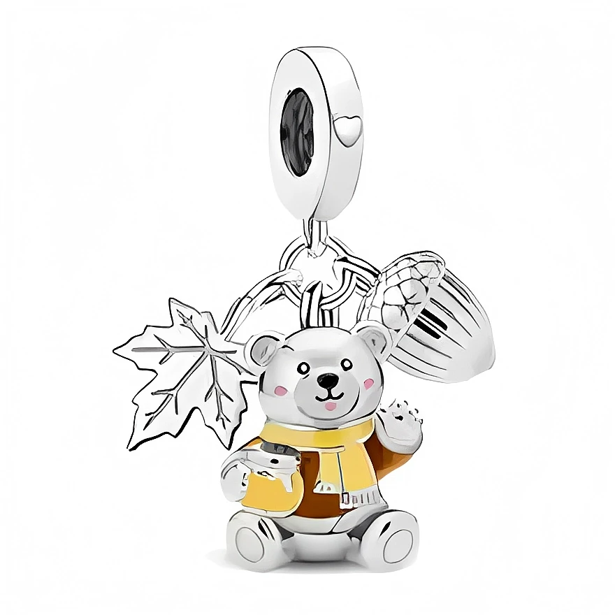 Ce charm en argent 925 met en scène un petit ours assis, vêtu d’un gilet et d’une écharpe jaune moutarde, tenant un mug fumant entre ses pattes. Derrière lui pendent une grande feuille nervurée et un gland détaillé, créant une ambiance de balade en forêt idéale pour les amoureux de l’automne.

Caractéristiques :

- Matière : Argent 925 avec émaux jaune et marron clair
- Design : Ourson assis avec mug, accompagné d’une feuille et d’un gland suspendus
- Coloris : Argent brillant, jaune moutarde, touches de ma