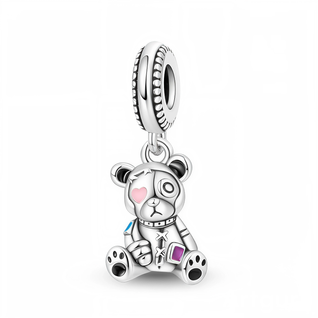 Ce charm pendentif en argent représente un ourson au style patchwork, assis avec un air attendrissant et orné de petits détails fantaisie. Son œil en forme de cœur rose, ses pattes contrastées et les touches d’émail coloré sur son corps lui donnent un look à la fois mignon et légèrement décalé, idéal pour exprimer une personnalité unique et sensible.