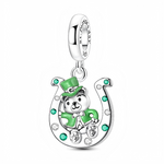La bélière en argent 925 est gravée « St. Patrick’s day » et reliée à un grand fer à cheval brillant par un double anneau mobile. À l’intérieur, l’ourson porte un manteau et un haut‑de‑forme verts façon lutin irlandais, tandis que le fer à cheval est ponctué de pierres rondes vert émeraude et claires qui renforcent le thème porte‑bonheur.