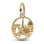 Charm Paris Skyline en argent 925, inspiré de l’élégance de la ville lumière. Son design rond met en valeur des monuments emblématiques de Paris, dont la tour Eiffel, l’Arc de Triomphe et d’autres silhouettes architecturales iconiques, dans une finition dorée lumineuse rehaussée de petits oxydes de zirconium clairs. Compatible avec les bracelets de type Pandora, il se glisse facilement sur la plupart des bracelets à maillons ou rigides pour apporter une touche chic et romantique à votre composition.