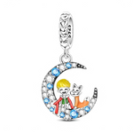 Ce charm pendentif en argent met en scène un petit garçon blond et son renard assis ensemble dans un croissant de lune pavé de zirconias blancs et de pierres bleues éclatantes. La bélière est décorée de petits cœurs ajourés, renforçant l’esprit tendre et poétique de ce bijou.