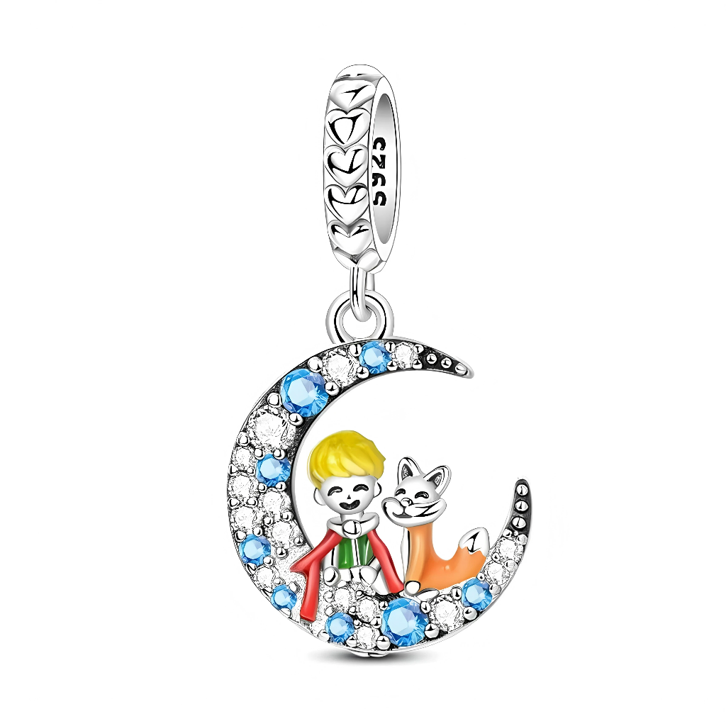 Ce charm pendentif en argent met en scène un petit garçon blond et son renard assis ensemble dans un croissant de lune pavé de zirconias blancs et de pierres bleues éclatantes. La bélière est décorée de petits cœurs ajourés, renforçant l’esprit tendre et poétique de ce bijou.