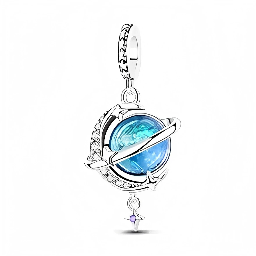 Ce charm représente une sphère bleu océan enserrée dans un anneau façon planète, en argent 925 finement ouvragé de motifs célestes. Une petite silhouette suspendue au bas du globe, ornée d’une pierre violette, évoque un danseur ou un rêveur flottant dans l’univers, pour un bijou poétique à porter au quotidien.