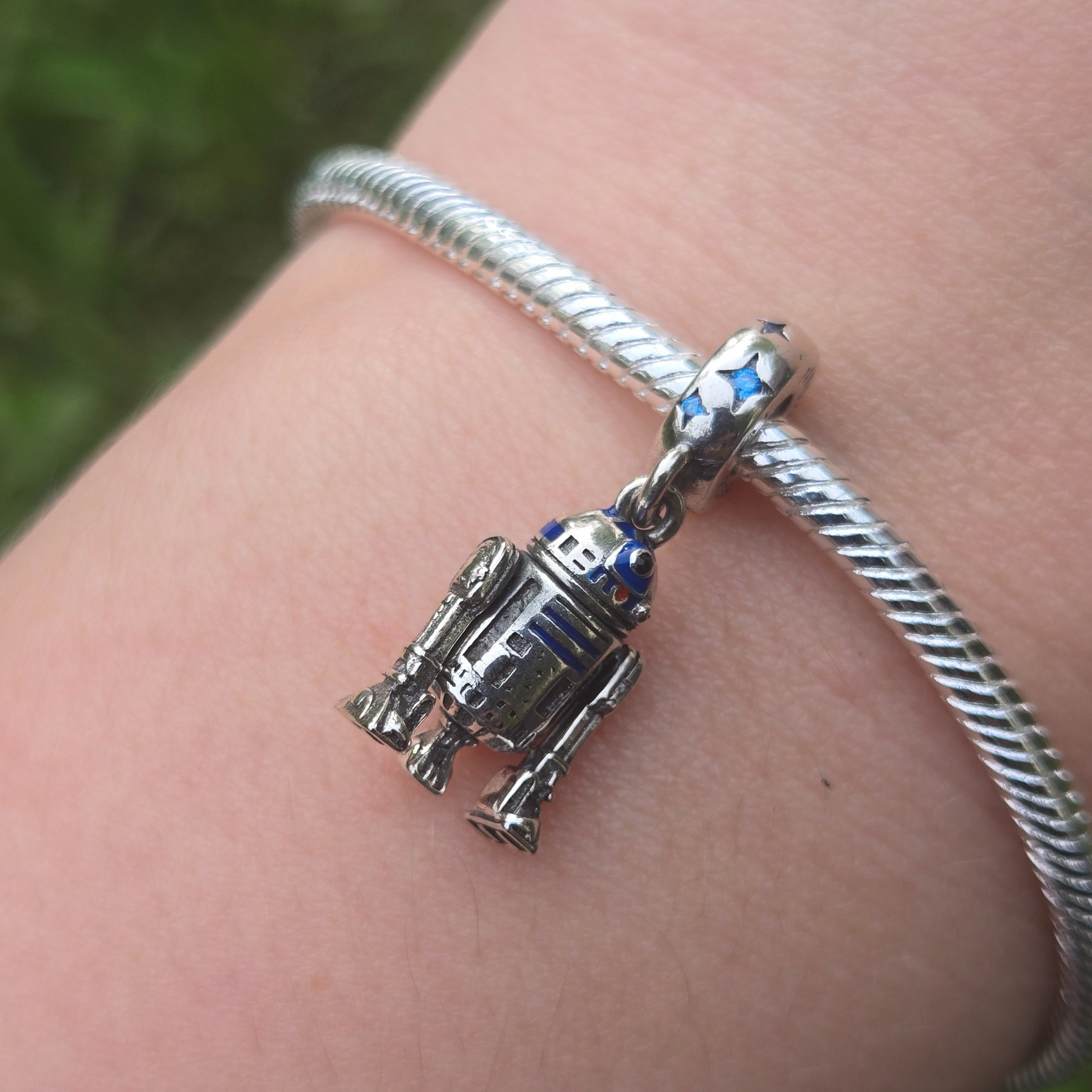 Ajoutez une touche d'aventure galactique à votre collection avec ce charm représentant R2-D2, le droïde astromécano emblématique de Star Wars. Conçu en argent sterling S925, ce charm capture avec précision les détails distinctifs et le design emblématique de R2-D2.