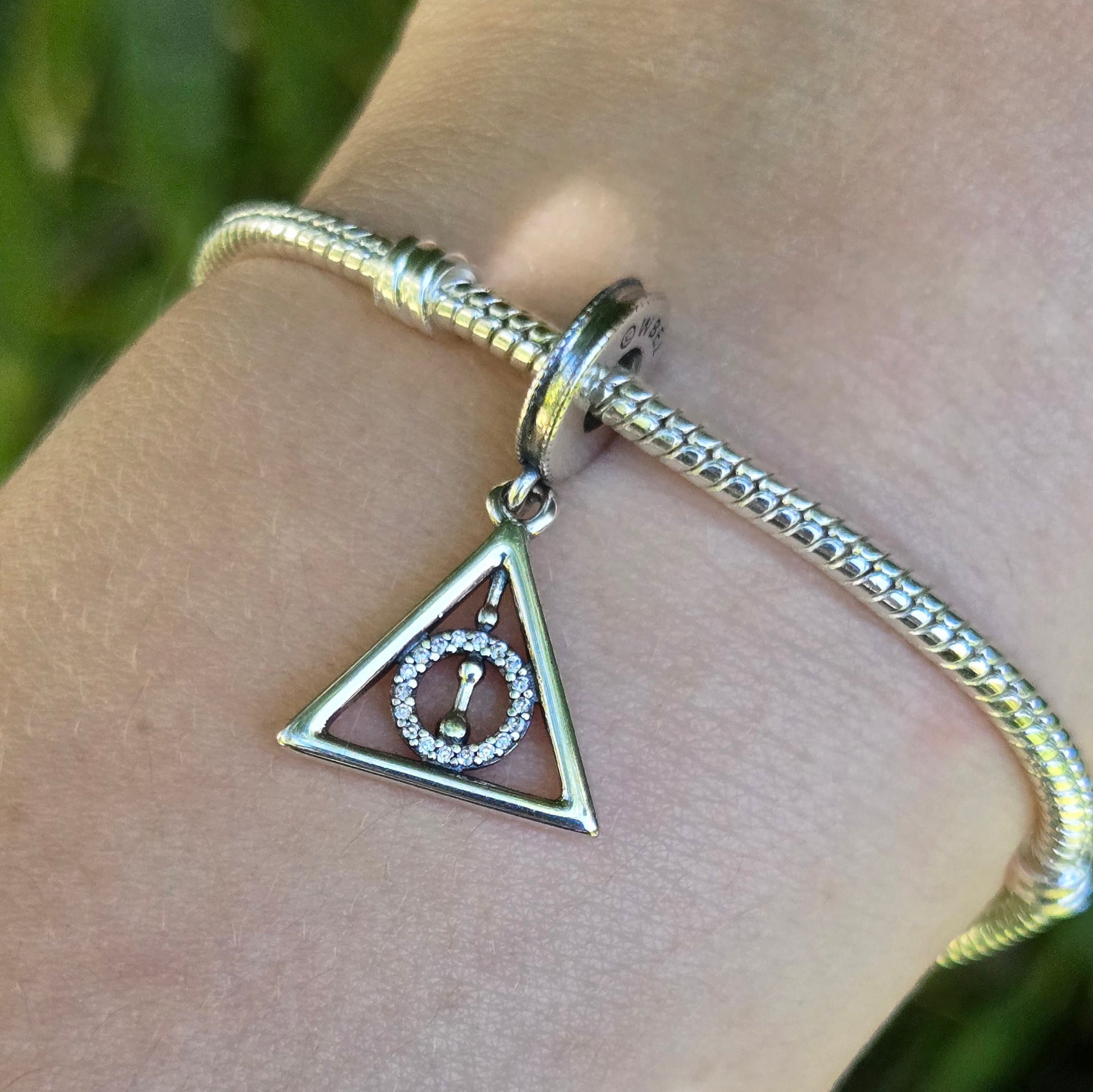 Affichez votre fascination pour les symboles légendaires de la saga Harry Potter avec ce charm pendentif Reliques de la Mort en argent sterling 925. Représentant le célèbre triangle des Reliques de la Mort (la Baguette de Sureau, la Pierre de Résurrection et la Cape d'Invisibilité), ce charm est un incontournable pour les fans de la magie et des mystères de Poudlard. Compatible avec les bracelets Pandora, ce pendentif ajoutera une touche mystique à votre collection.