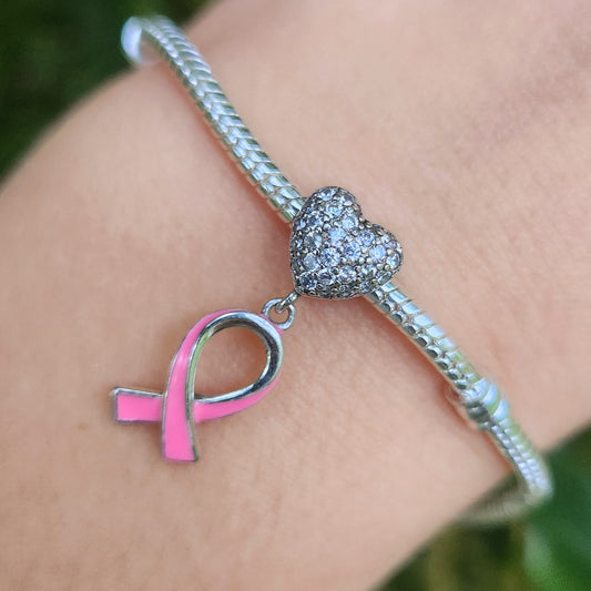 Exprimez votre soutien à la cause d'Octobre Rose avec ce charm émouvant alliant le ruban rose, symbole mondial de la lutte contre le cancer du sein, et un cœur, représentant l'amour, la solidarité et l’espoir. Fabriqué en argent 925, ce charm incarne la force et la résilience des personnes touchées par cette maladie, tout en ajoutant une touche élégante à votre collection.