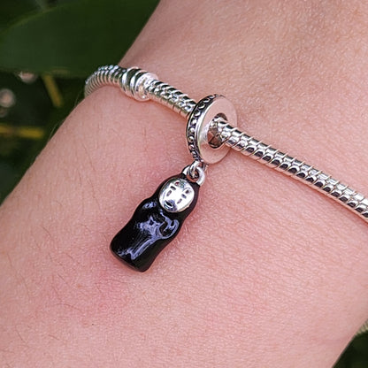Invitez la magie du Voyage de Chihiro dans votre collection avec ce charm Sans Visage. En argent 925, il reflète le mystère et l’élégance de cet énigmatique personnage du chef-d’œuvre de Miyazaki.