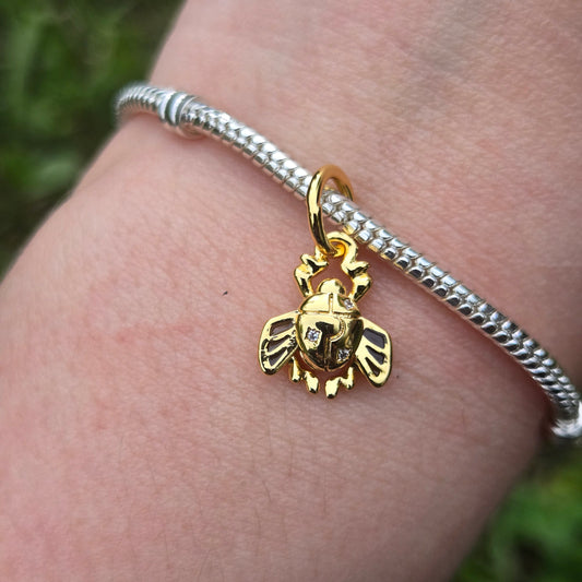 Ajoutez une touche mystique et élégante à votre bracelet avec ce charm Scarabée Doré. Ce bijou en argent 925, accentué de détails dorés, évoque la force et la renaissance, inspiré des symboles égyptiens.