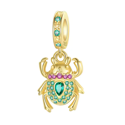 Apportez une touche d’élégance mystique à votre collection avec ce charm pendentif scarabée en finition or, sublimé par des strass verts étincelants. Ce bijou raffiné allie symbole de protection et éclat précieux, idéal pour celles et ceux qui recherchent un accessoire à la fois chic et chargé de sens.