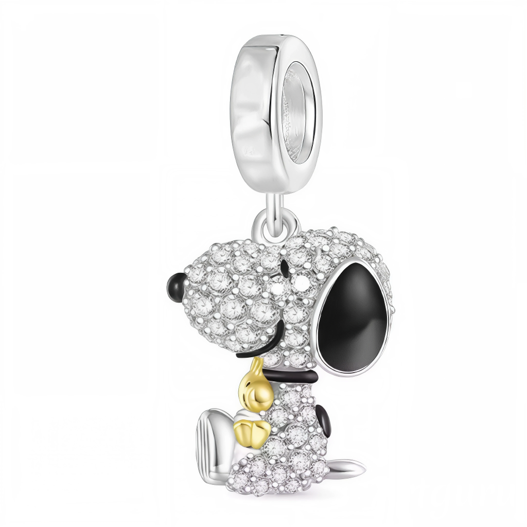 Laissez-vous charmer par ce charm pendentif en argent 925 représentant Snoopy assis, tenant tendrement Woodstock dans ses bras. Entièrement orné de strass scintillants, ce bijou illumine votre collection avec une touche de douceur et d’éclat. Un hommage brillant à l’amitié iconique de Peanuts, parfait pour les amateurs de bijoux élégants et originaux.