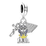 Ce charm met en lumière une figure de sphinx assis en argent 925, rehaussée de rayures émaillées bleu nuit et d’un plastron jaune lumineux pour une allure majestueuse. Il est accompagné d’une pyramide stylisée et d’un fouet croisé, créant un ensemble riche en détails qui évoque les mystères et la grandeur des civilisations anciennes.