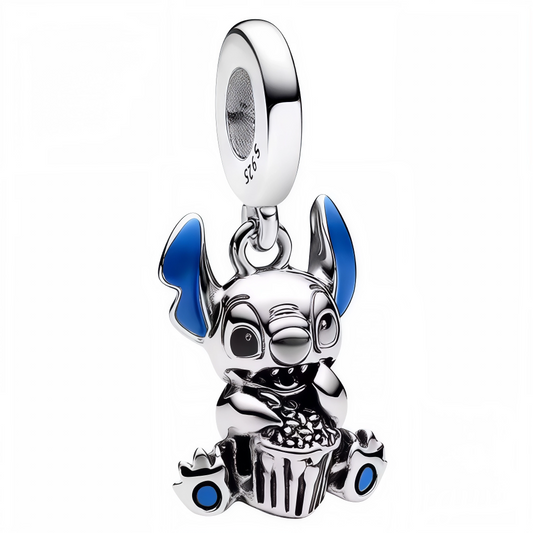 Apportez une dose de fun et de gourmandise à votre collection avec ce charm pendentif représentant Stitch assis par terre, dans une posture adorable et décontractée. Finement travaillé en argent brillant avec des touches de bleu dans l’intérieur des oreilles et sur les pieds, Stitch savoure un seau de popcorn placé entre ses jambes. Ce bijou capture parfaitement son côté espiègle et attachant, pour un accessoire plein de vie et de fantaisie.