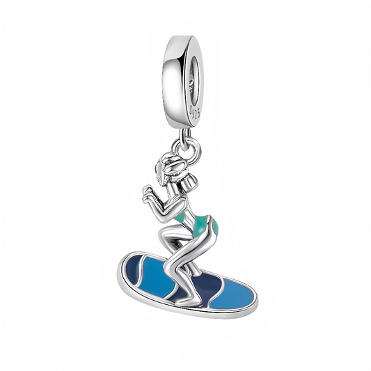 Laissez-vous porter par l’esprit de liberté et d’aventure avec ce charm surfeuse, idéal pour faire voyager vos bijoux vers les plus belles vagues ! Sculpté en argent 925, ce pendentif représente une surfeuse dynamique, capturée en pleine action sur une planche aux nuances de bleu intense et d’émail turquoise. Son design élégant et ses détails finement travaillés illustrent parfaitement la passion pour l’océan et la glisse. Un bijou à offrir ou à s’offrir pour tous les amoureux de la mer et des sports nautiq