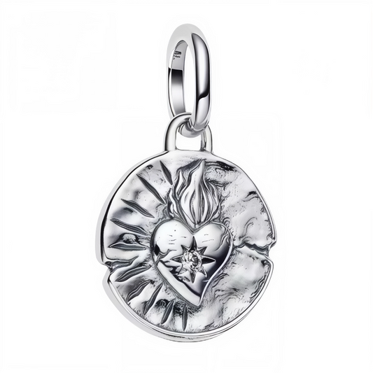 Sublimant l’iconique symbole du Cœur Sacré, ce charm pendentif en&nbsp;argent 925&nbsp;capture une flamme protectrice et des rayons gravés, façon médaillon talisman usiné avec un effet martelé ancien, pour un rendu à la fois mystique et intemporel. Inspiré des ex-votos et médailles dévotionnelles, il évoque l’amour, la protection et la force intérieure, idéal pour composer un bracelet à charms ou illuminer une chaîne fine en collier. Sa compatibilité avec les bracelets de style Pandora en fait un accessoire