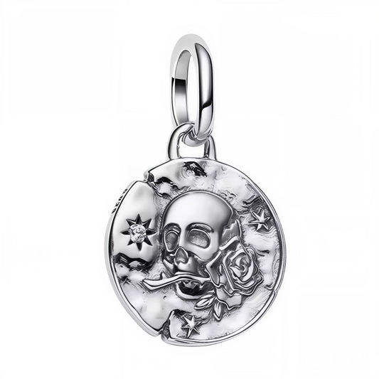 Ce charm pendentif en&nbsp;argent 925&nbsp;présente une tête de mort tenue par une rose, entourée d’étoiles et d’un croissant de lune sur un médaillon texturé, pour un style talisman gothique et raffiné. Inspiré du memento mori, il rappelle la beauté éphémère de la vie et invite à vivre pleinement, tandis que la rose symbolise l’amour et la passion, et la lune les cycles et l’intuition. Compatible avec les bracelets à charms de style Pandora et élégant porté en collier, il s’ajoute aisément à une collection
