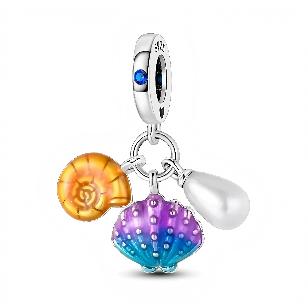 Ce charm pendentif en argent réunit trois breloques marines : un coquillage jaune ambré en forme de spirale, une grande coquille bicolore bleu-turquoise et violet, et une perle blanche tombante. La bélière lisse est sertie d’un cristal bleu océan et d’un petit cœur gravé, évoquant les vacances au bord de la mer et les souvenirs de plage.