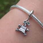 Apportez une touche de magie cinématographique à votre collection avec ce Charm - WALL-E, fabriqué en argent sterling S925. Inspiré par le célèbre personnage du film d’animation de Pixar, ce charm représente WALL-E, le petit robot au grand cœur, qui nous rappelle l'importance de la préservation de notre planète et de l'amour.