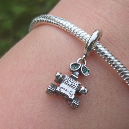 Apportez une touche de magie cinématographique à votre collection avec ce Charm - WALL-E, fabriqué en argent sterling S925. Inspiré par le célèbre personnage du film d’animation de Pixar, ce charm représente WALL-E, le petit robot au grand cœur, qui nous rappelle l'importance de la préservation de notre planète et de l'amour.