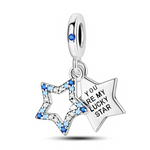 Ce charm pendentif en argent 925 se compose de deux étoiles : l’une ajourée, entièrement pavée de cristaux dégradés de bleu et de blanc, et l’autre pleine, gravée du message « YOU ARE MY LUCKY STAR » pour une déclaration tendre et porte-bonheur. La bélière lisse est rehaussée d’une petite pierre bleue qui rappelle l’éclat de la voûte céleste.