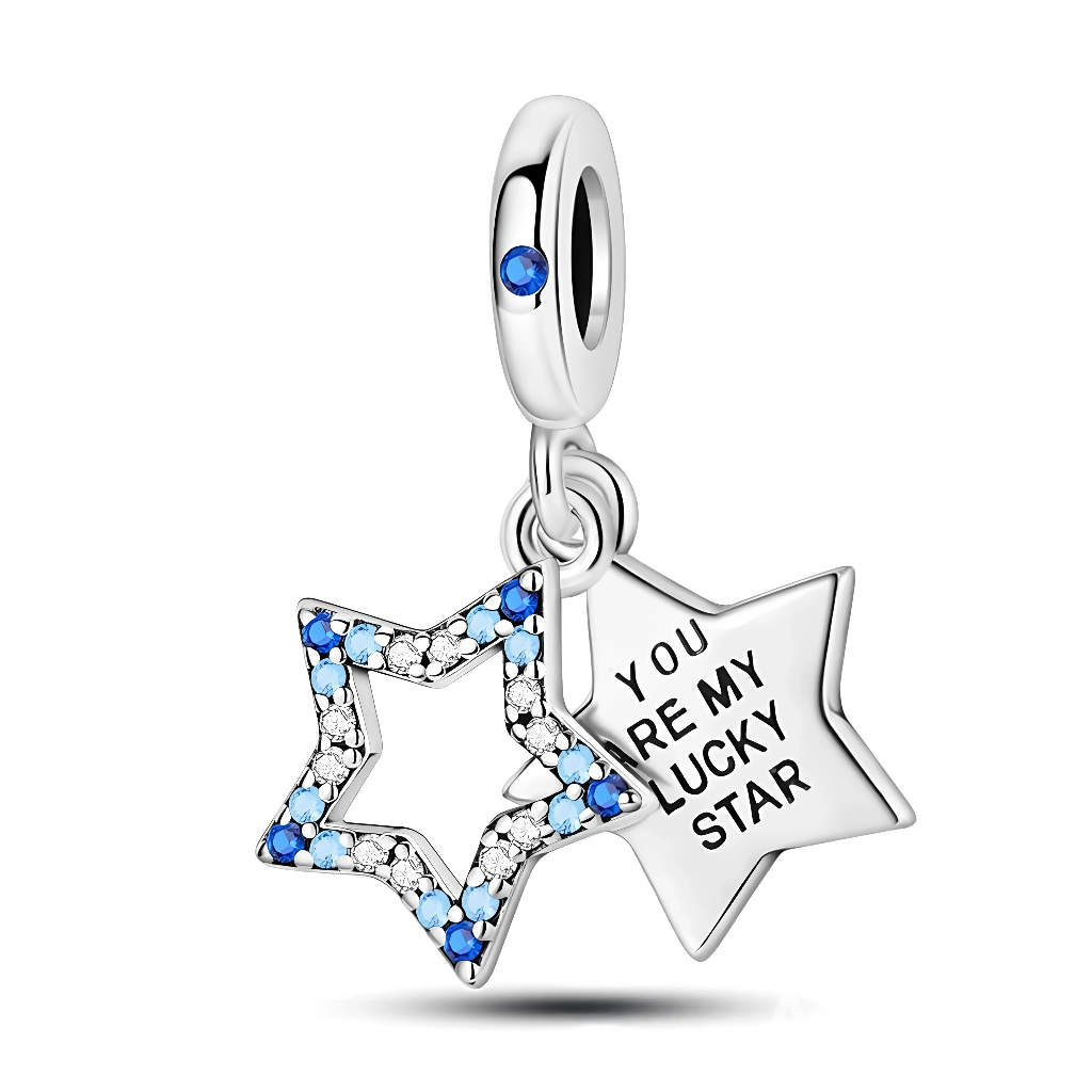 Ce charm pendentif en argent 925 se compose de deux étoiles : l’une ajourée, entièrement pavée de cristaux dégradés de bleu et de blanc, et l’autre pleine, gravée du message « YOU ARE MY LUCKY STAR » pour une déclaration tendre et porte-bonheur. La bélière lisse est rehaussée d’une petite pierre bleue qui rappelle l’éclat de la voûte céleste.