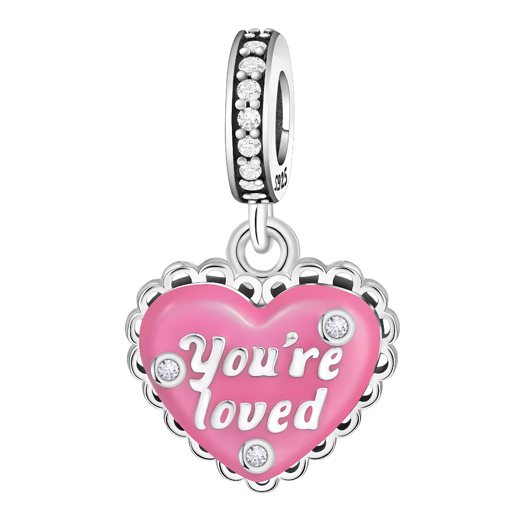 Ce charm pendentif en argent 925 affiche un cœur rose émaillé vibrant avec l'inscription "YOU'RE LOVED" en lettres élégantes, pavé de strass étincelants et bordé de dentelle fine pour une déclaration d'amour joyeuse et scintillante. La bélière texturée avec strass et gravée « S925 » assure une fixation chic.

Caractéristiques :

Matière : Argent 925 (S925)
Design : Cœur fuchsia laqué rose avec texte love, micro-strass multiples et bordure wavy, sur anneau pavé gravé.
Style : Affectueux et festif, idéal comm