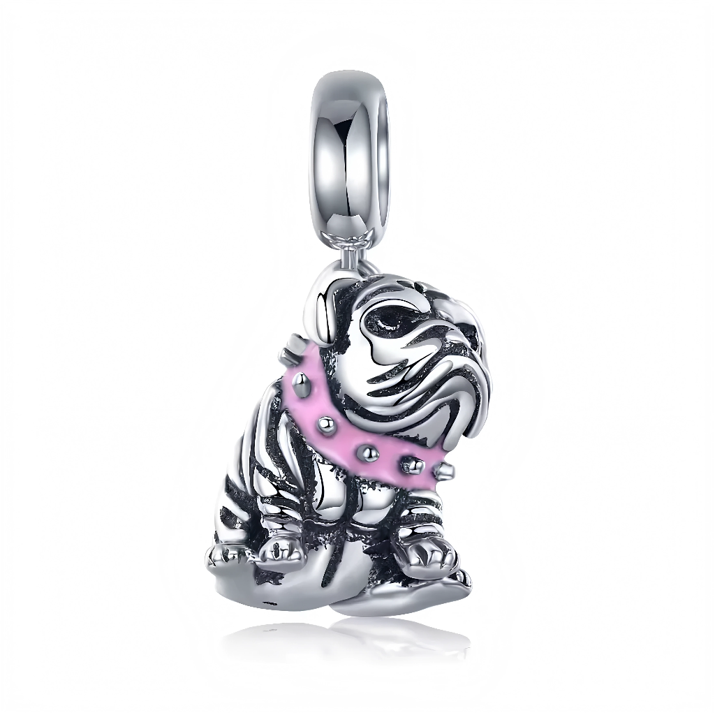 Ce charm pendentif capture un bouledogue français au visage plissé caractéristique, sculpté en argent sterling avec un pelage texturé et un air espiègle et attendrissant. Son collier rose vif clouté de strass blancs ajoute une touche rock et féminine, soulignant sa personnalité audacieuse et câline. Une patte levée et la queue enroulée complètent ce portrait fidèle et charmant du compagnon à quatre pattes.