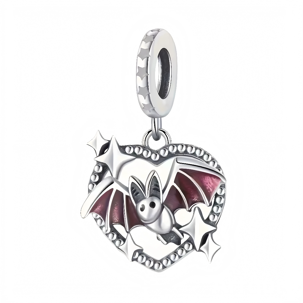 Ce charm pendentif présente une adorable petite chauve-souris aux ailes translucides en émail mauve, nichée au cœur d’un cadre cœur ajouré en argent sterling pour un effet gothique mignon et scintillant. Les ailes déployées encadrent le cœur comme un vol gracieux, avec des petites étoiles argentées qui évoquent la nuit étoilée et les mystères d’Halloween. Le visage rond et expressif de la chauve-souris ajoute une touche de tendresse inattendue, parfaite pour célébrer l’amour des créatures nocturnes.