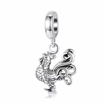 Ce charm pendentif dépeint un coq fier en argent sterling, symbole du zodiaque chinois pour les années 1957, 1969, 1981, 1993, 2005, 2017 et 2029, avec une crête bombée et des plumes sculptées en relief. Sa queue déployée en volutes gracieuses et ses ergots solides soulignent sa posture dynamique et vigilante, annonciatrice de l’aube. L’anneau supérieur permet une suspension fluide, idéal pour porter chance et ambition.