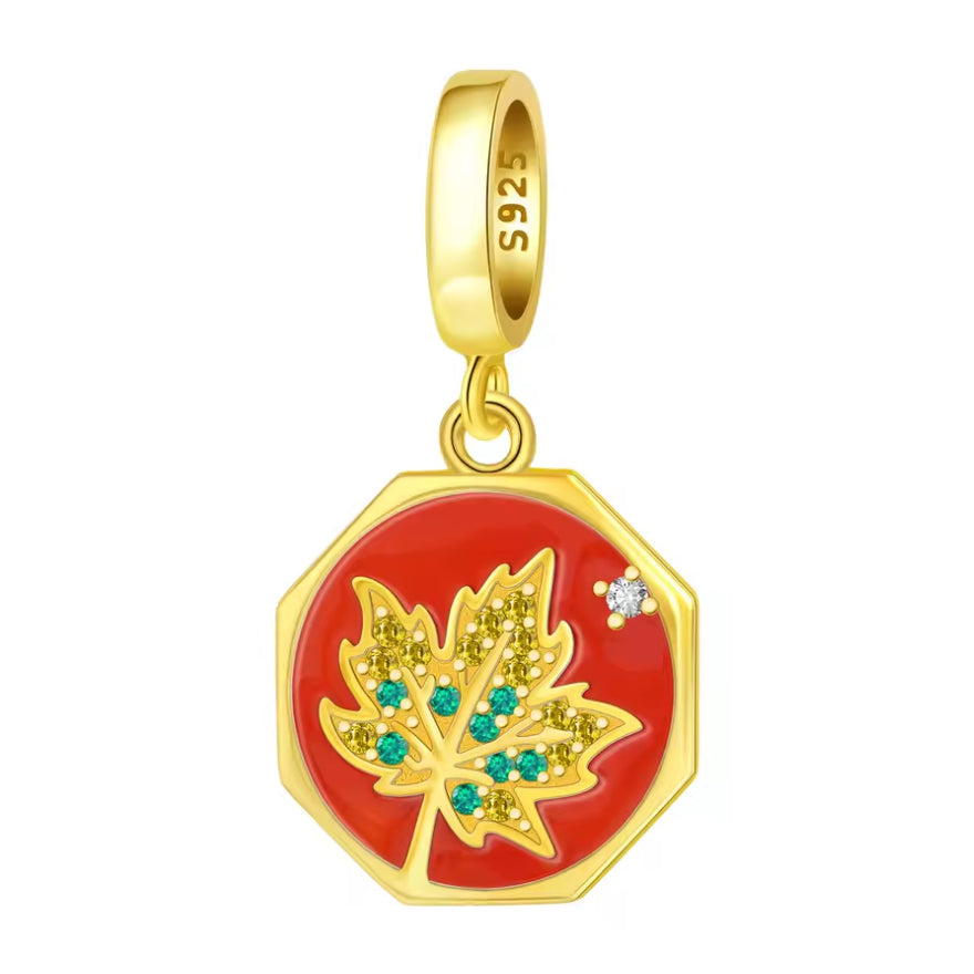 Ce charm se présente sous la forme d’un médaillon octogonal doré, dont le centre rouge vif met en valeur une feuille d’érable ajourée, pavée de petits cristaux verts et jaune doré. Un strass blanc façon étoile vient illuminer le coin du médaillon, tandis que la bélière lisse plaquée or assure une ligne élégante et moderne. Une pièce forte, parfaite pour un thème automne chic, Canada lover ou simplement pour apporter une touche de couleur chaude à un bracelet.
