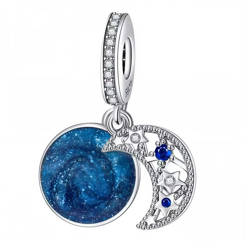 Plongez dans l’infini du cosmos avec ce charm pendentif délicatement ouvragé en argent : une majestueuse lune ajourée parsemée d’étoiles scintillantes et de pierres bleues, accompagnée d’un disque illustrant une magnifique galaxie bleu nuit. Les finitions minutieuses et les détails étincelants évoquent la magie des nuits étoilées et l’élégance céleste, tandis que l’anneau serti de cristaux ajoute une touche raffinée à l’ensemble. Idéal pour sublimer un bracelet Pandora ou un collier, ce bijou est une invita
