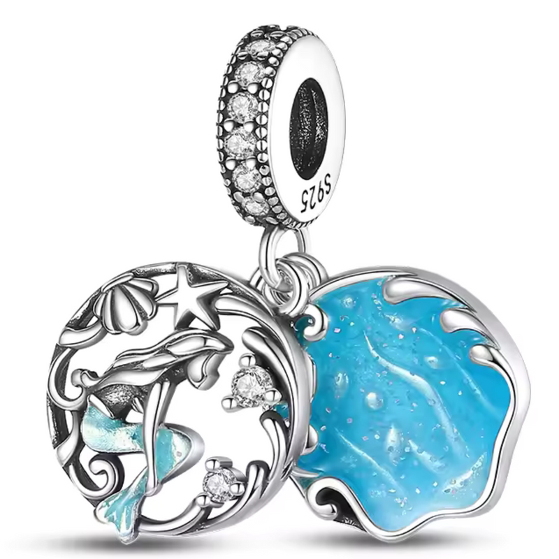 Ce charm double en argent 925 dévoile sirène turquoise gracieuse nageant queue écailleuse nageoire, face à médaillon vague bleu émaillé coquillages étoiles décoratifs, zircones étincelantes. Symbole mystère mer liberté rêves aquatiques.

Caractéristiques

Matière : Argent 925 émail bleu turquoise zircone pavée.
Design : Sirène médaillon vague coquillages, bélière diamantée.
Compatibilité : Bracelets colliers thèmes mer fantasy.